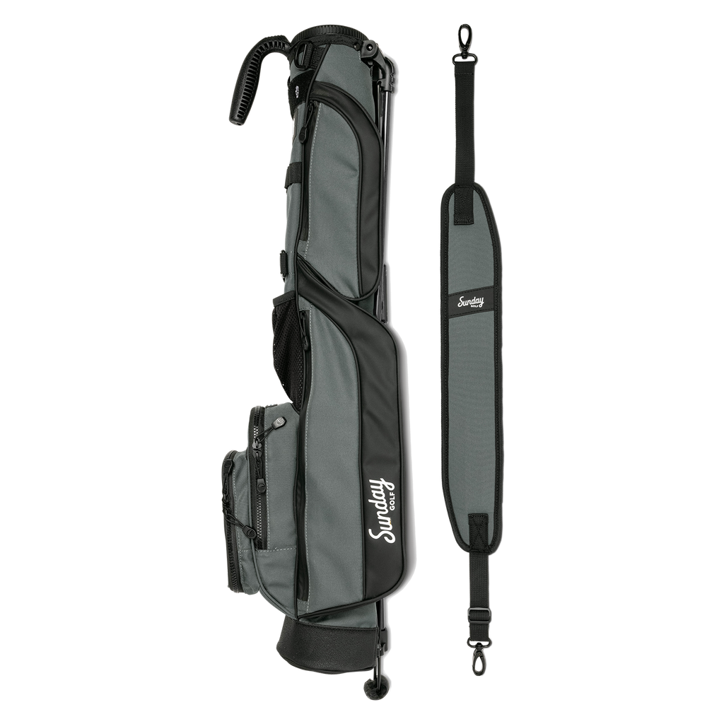 A full shot of Loma golf bag in midnight green laying flat sideways beside its single strap